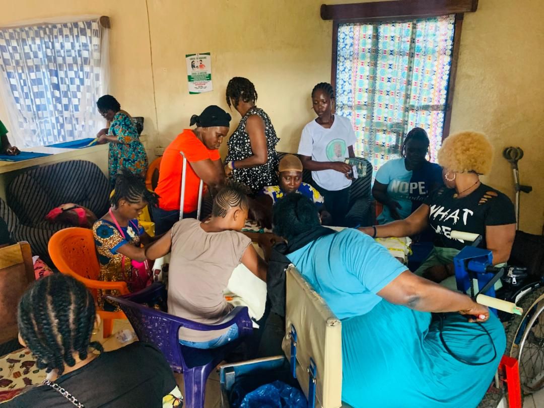 Group of women with disabilities collaborating around a work table on reusable pad production